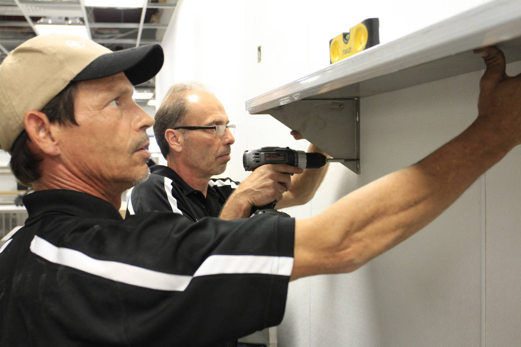 CES Kitchen Installers installing a Shelf in the Kitchen Prep area.